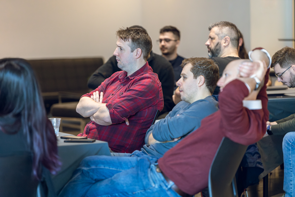 A group of people sat starting at a talk