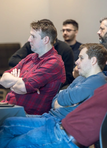 A group of people sat starting at a talk