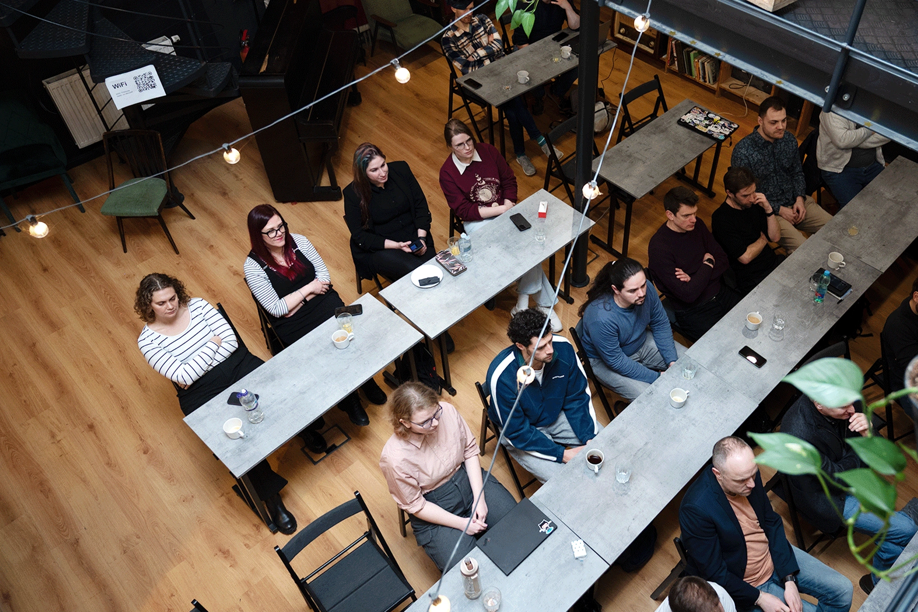 A shot of a group of people at tables all facing the same direction lisntening to a talk
