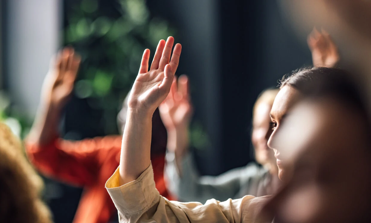 Young woman with hand up for Membership organisation