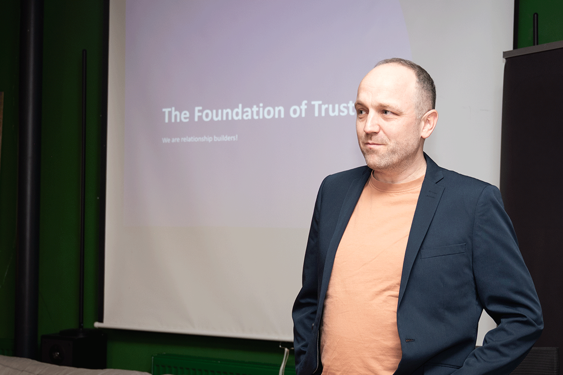 A person standing in front of a dispay to give a talk