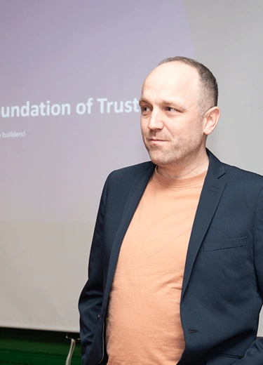 A person standing in front of a dispay to give a talk